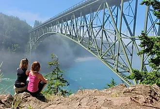 Group of women by ocean in foggy morning in Deception Pass Bridge Park, Anacortes, Washington.