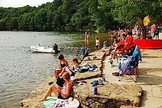 People enjoying their leisure time by the beautiful Walden Pond in Concord, Massachusetts.