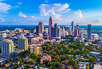 Charlotte North Carolina skyline on a bright sunny day with a few clouds in the sky.