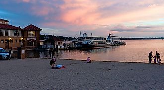 City of Lake Geneva, WISCONSINUSA-September 18, 2022: People gathering at the beach near Lake Geneva, showing the boat docks during a gorgeous pinky and cloudy sunset