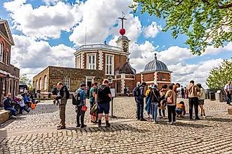 London, UK: Tourists standing on Greenwich meridian in Royal Observatory