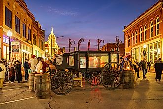 Night view of the Guthrie Victorian Walk in Oklahoma with historic buildings lit along the street. Image Credit: Kit Leong / Shutterstock