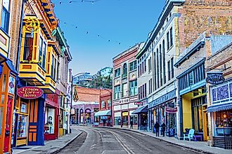 Buildings lining Main Street on a clear day at the edge of Bisbee, Arizona
