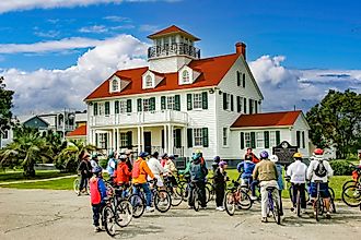 St. Simons Island, Georgia: Leader of a bicycle tour group giving instruction in front of the St. Simons Island Light, a lighthouse located on the southern tip of the island. Editorial credit: Bob Pool / Shutterstock.com
