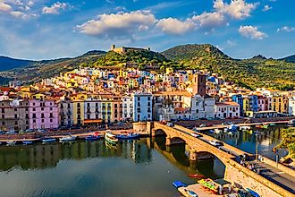 Aerial view of Bosa, Sardinia, with colored houses and a medieval castle.
