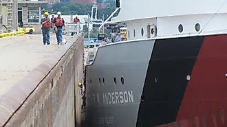 A crew member and shoreside line handlers help guide the Great Lakes freighter Arthur M. Anderson into the Poe Lock at Sault Ste. Marie, Michigan. 