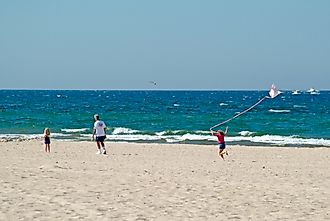 Girl flies kite on beach at Grand Haven State Park on Lake Michigan.