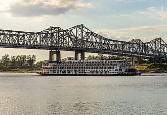 Natchez, Mississippi: Paddle steamer river cruise boat, American Queen, departs under the interstate bridge. Editorial credit: Steve Heap / Shutterstock.com