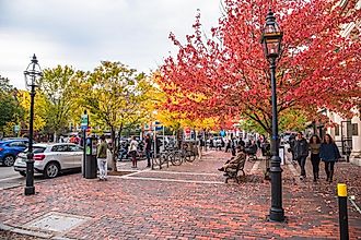 People enjoying a warm autumn afternoon in a small brick square along Pleasant Street in downtown. Portsmouth is a New Hampshire port city on the Piscataqua River.