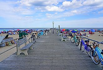 View of the boardwalk along the beach in Ocean Grove, a town on the New Jersey Shore, known for its historic Victorian houses. Editorial credit: EQRoy / Shutterstock.com