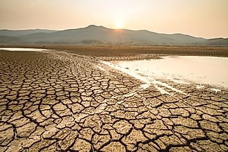 Cracked, dry lakebed caused by extreme heat and drought, illustrating the impact of climate change during summer.