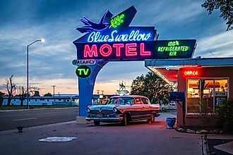 Classic neon sign and vintage Hudson Rambler vehicle at Blue Swallow Motel, a landmark hotel on historic Route 66. Editorial credit: Sandra Foyt / Shutterstock.com