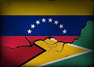 Flags of Venezuela and Guyana against a background of a wall with cracks. (Credit: Evgeny Simonov via Shutterstock)