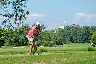 Golfer finishing a putt on the green at Audubon Park Golf Club in New Orleans, Louisiana. Editorial credit: William A. Morgan / Shutterstock.com