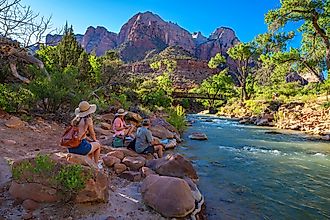 isitors relax by a river in Zion National Park near Springdale, Utah.