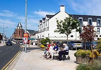  People sitting while chatting outside the Newcastle Centre on the central promenade in Newcastle County Down Northern Ireland