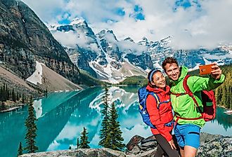 Moraine Lake, tourists taking selfie picture on Canada travel hike.
