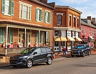 A woman and her dog walk along main street in Jonesborough decorated for Thanksgiving.