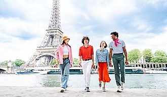 Group of happy friends visiting the Eiffel Tower in Paris, France. Image Credit oneinchpunch via Shutterstock.