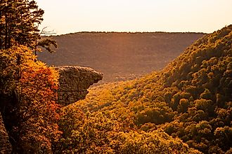 The sun rises over Whitaker Point, known as Hawksbill Crag, in Arkansas as the fall colors begin to set in on the trees. 