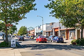 Cars on the street in downtown Astoria, Oregon with Astoria-Megler Bridge in the background