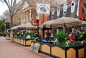 Folks enjoy an alfresco meal in Merchants Square, a retail and dining area near Colonial Williamsburg, Virginia, via James Kirkikis / Shutterstock.com