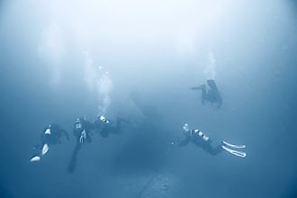 Divers searching for a shipwreck at sea.