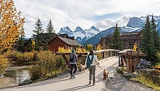 Residents walking the dogs in Town of Canmore in fall season. Image Credit Shawn.ccf via Shutterstock.