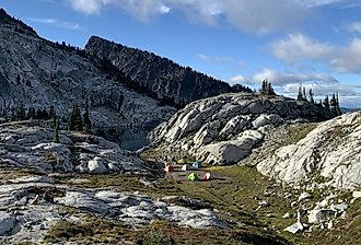 Camping near a rocky outcrop in the Pacific Northwest backpacking, summer hiking, colorful tents.