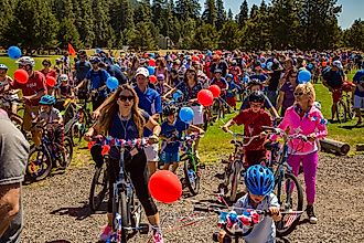 Children and adults just starting a ride in a 4th of july parade at Blask Butte Ranch resort near Sisters, Oregon. Editorial credit: Bob Pool / Shutterstock.com