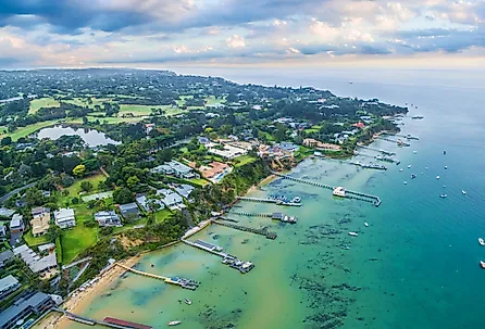 Sorrento suburb coastline with private piers and moored boats at sunrise, Victoria, Australia.