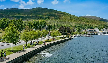 People walking along a path by the water, Lake George, New York.