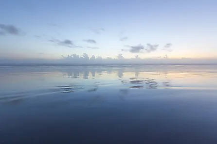 Ocean reflection of dusk sky on the beach. 