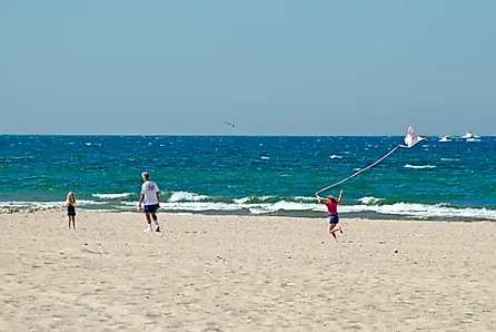 Girl flies kite on beach at Grand Haven State Park on Lake Michigan.
