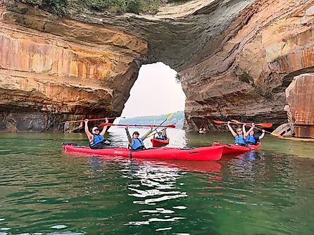 Pictured Rocks kayakers pose for a group photo in front of the famous Lover’s Leap sandstone arch. Image credit: Joshua Lutz