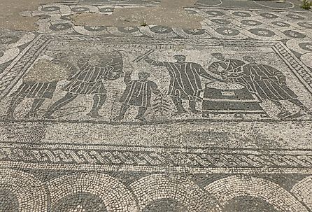 Black-and-white mosaic; depicted are grain measurers (mensores frumentarii) at work. Image credit MumblerJamie, CC BY-SA 2.0 <https://creativecommons.org/licenses/by-sa/2.0>, via Wikimedia Commons