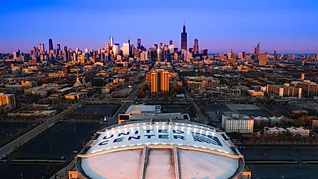 Beautiful Aerial View of Iconic United Center Stadium with Chicago Skyline in Background at Blue Hour. 