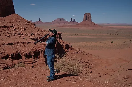 A member of the Navajo tribe playing flute in Monument Valley. 