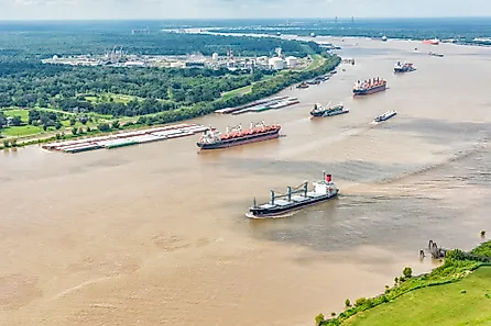 A variety of different cargo ships sailing along the Mississippi River near New Orleans