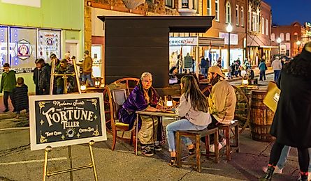 A fortune teller seated in a Victorian-style setting during the famous Guthrie Victorian Walk.
