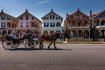 A horse-drawn carriage passes tourists by a row of ornate Victorian gingerbread houses in Cape May, New Jersey. Editorial credit: Steve Rosenbach / Shutterstock.com