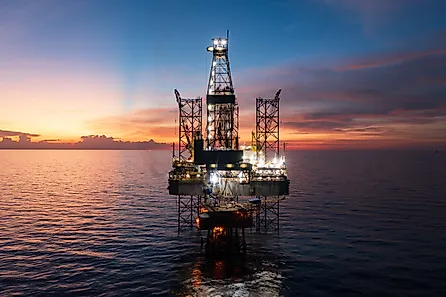 Aerial view of offshore jack up rig and offshore platform during sunset for oil and gas exploration and production.