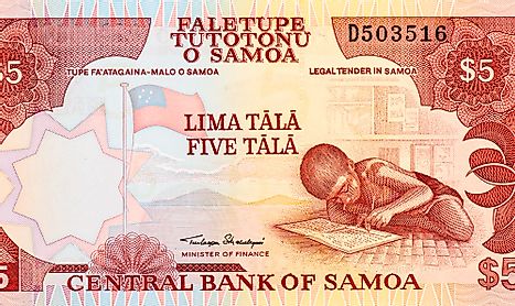 A 5 tālā banknote showing the national flag of Samoa, National Flag of Samoa, the view of Samoan coastline from a distance, and a child doing his homework.