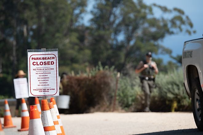 Closed regulation sign posted beside orange cones at a trail access point.