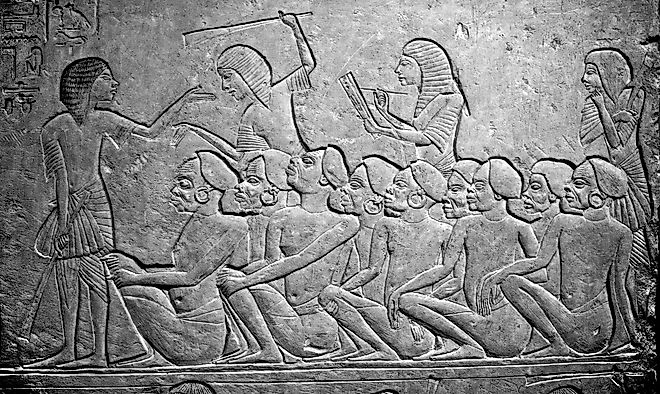 Kushite prisoners of war watched over by Egyptians, waiting to be deported into Egypt. 