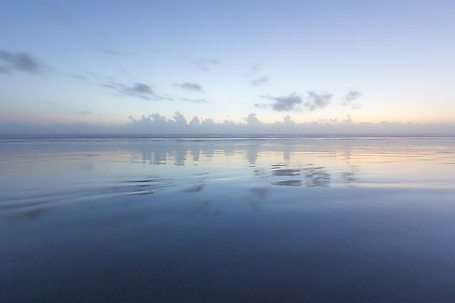 Ocean reflection of dusk sky on the beach. 