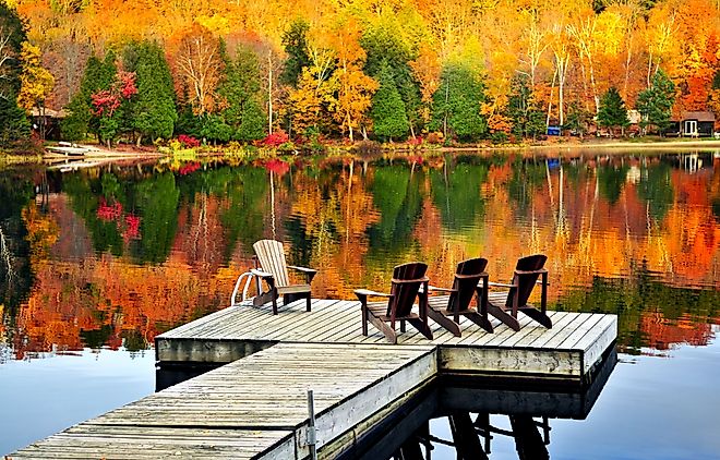 Wooden dock with chairs on calm fall lake. Image credit Elena Elisseeva via shutterstock