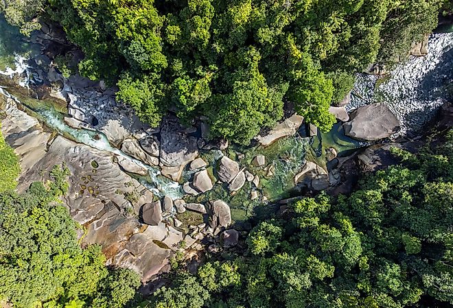 Daintree Rainforest from above with river rapids winding through lush jungle and boulders.