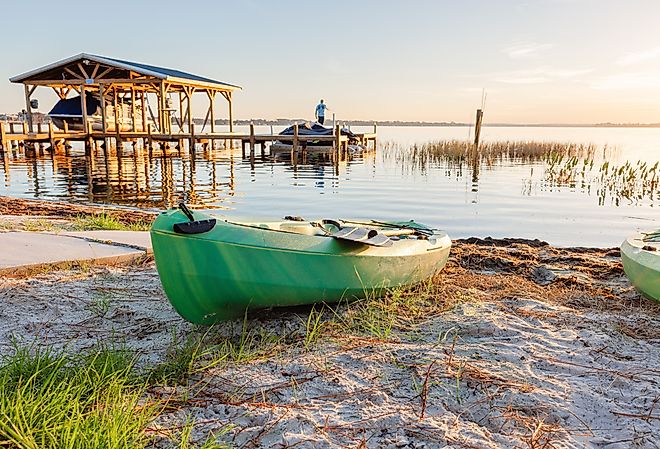  Beautiful lake sunrise with kayak on doc and fisherman in the distance in Mount Dora. Editorial credit: Cavan-Images / Shutterstock.com