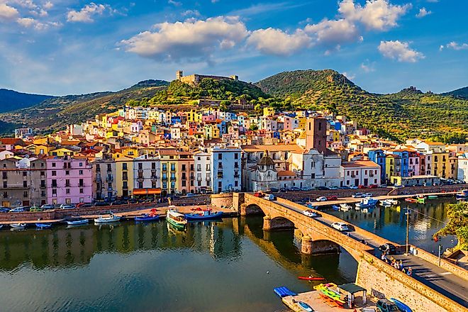 Aerial view of Bosa, Sardinia, with colored houses and a medieval castle.